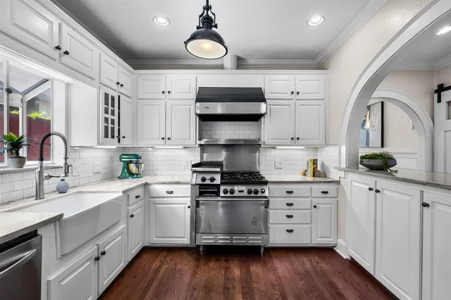 a kitchen with stainless steel appliances granite countertop a stove a sink and a refrigerator