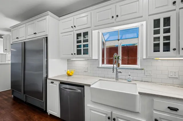 a kitchen with stainless steel appliances white cabinets and a refrigerator