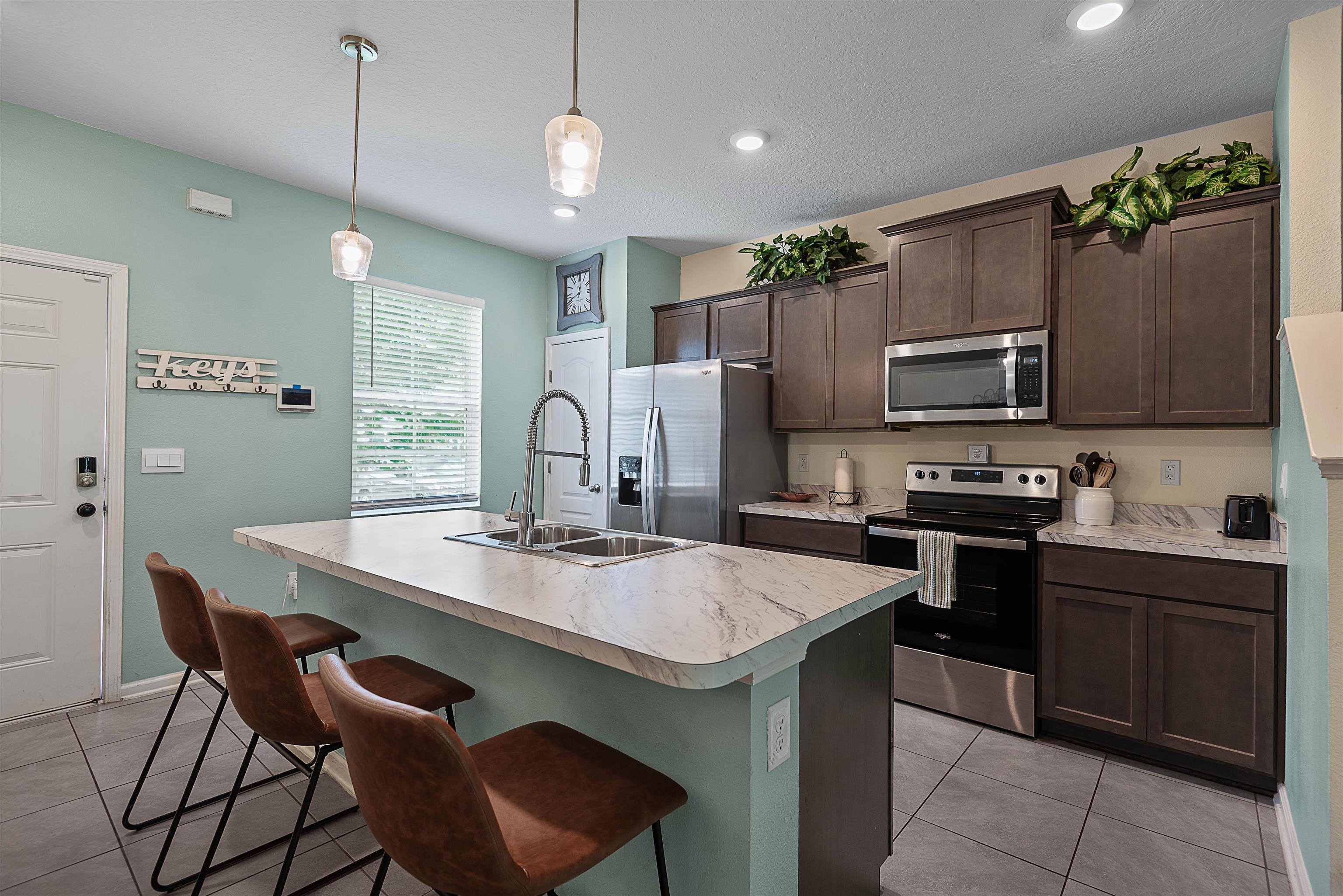 877 Rotary Road Jacksonville, FL 32211 - Photo 5 of 36 a kitchen with kitchen island a sink stove and microwave