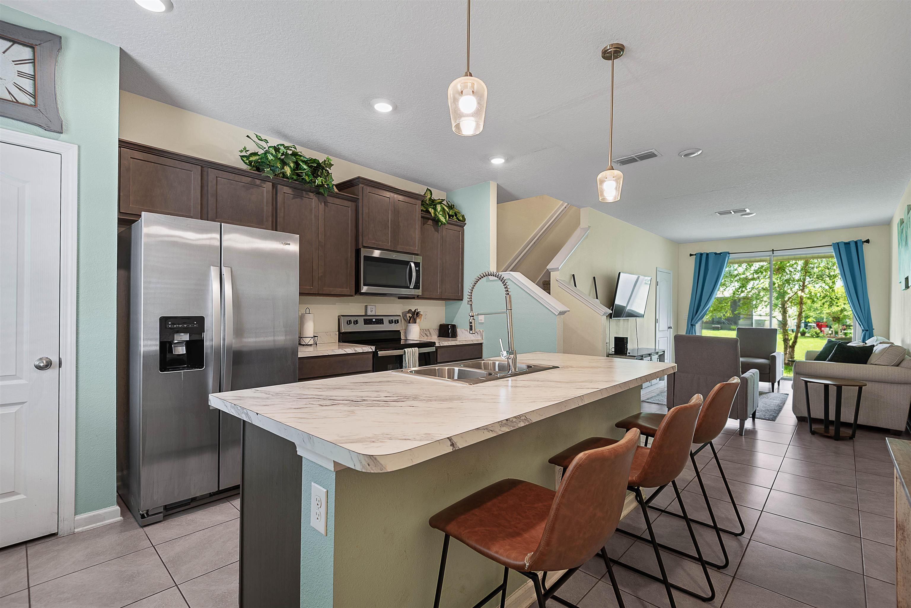877 Rotary Road Jacksonville, FL 32211 - Photo 6 of 36 a kitchen with granite countertop a table chairs stainless steel appliances and wooden floor
