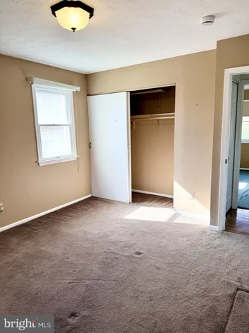 an empty room with a window and a fireplace