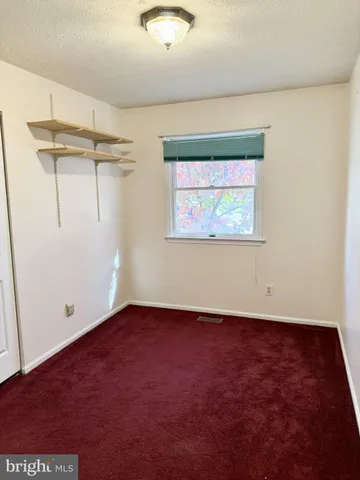 an empty room with a windows and a ceiling fan