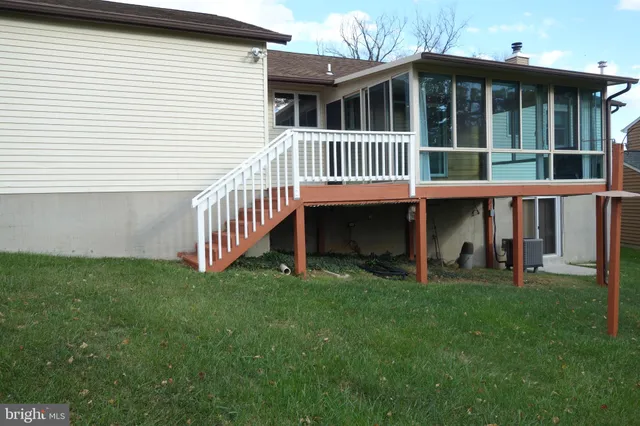 a view of a house with a yard and deck