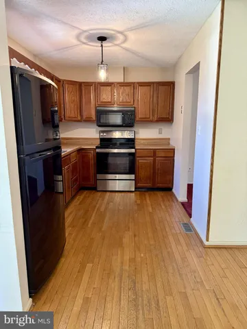 a kitchen with stainless steel appliances a refrigerator and a stove top oven