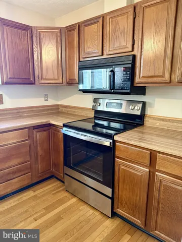 a kitchen with stainless steel appliances granite countertop a stove microwave and cabinets