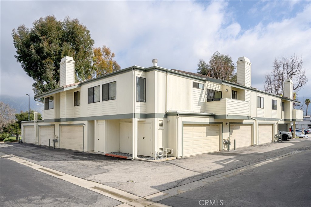 10475 Newhome Avenue, Unit 6 Sunland, CA 91040 - Photo 1 of 28 a view of a white building among the street with palm trees