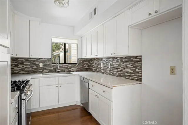 a kitchen with stainless steel appliances granite countertop a sink stove and cabinets