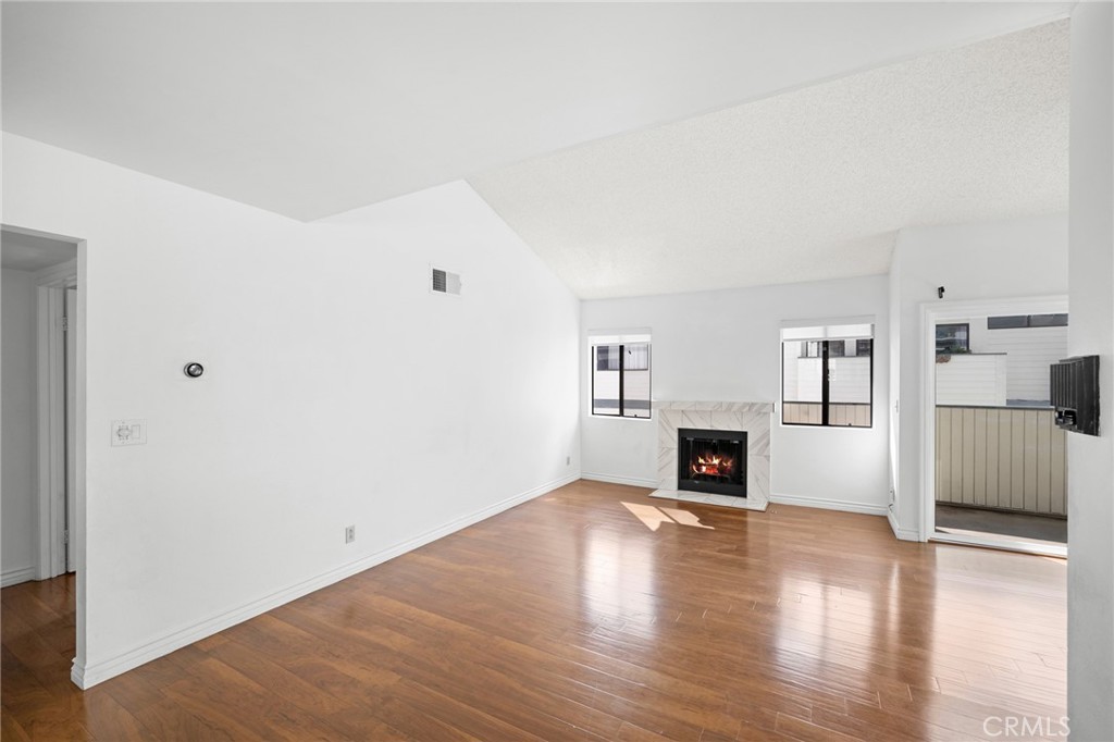 10475 Newhome Avenue, Unit 6 Sunland, CA 91040 - Photo 5 of 28 an empty room with fireplace wooden floor and windows