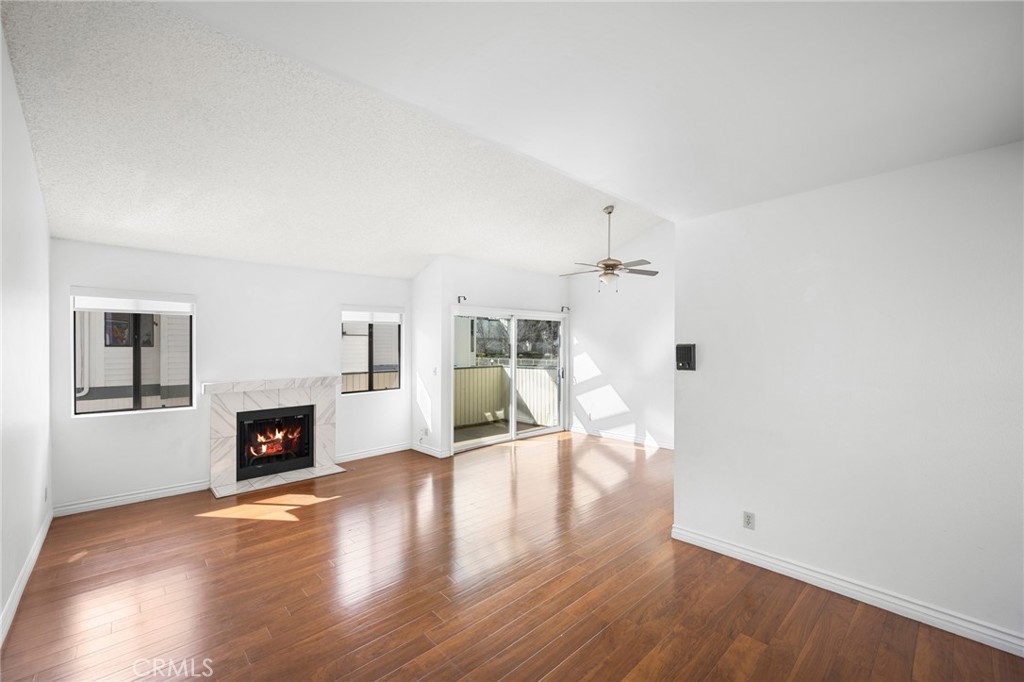 10475 Newhome Avenue, Unit 6 Sunland, CA 91040 - Photo 6 of 28 an empty room with fireplace and wooden floor