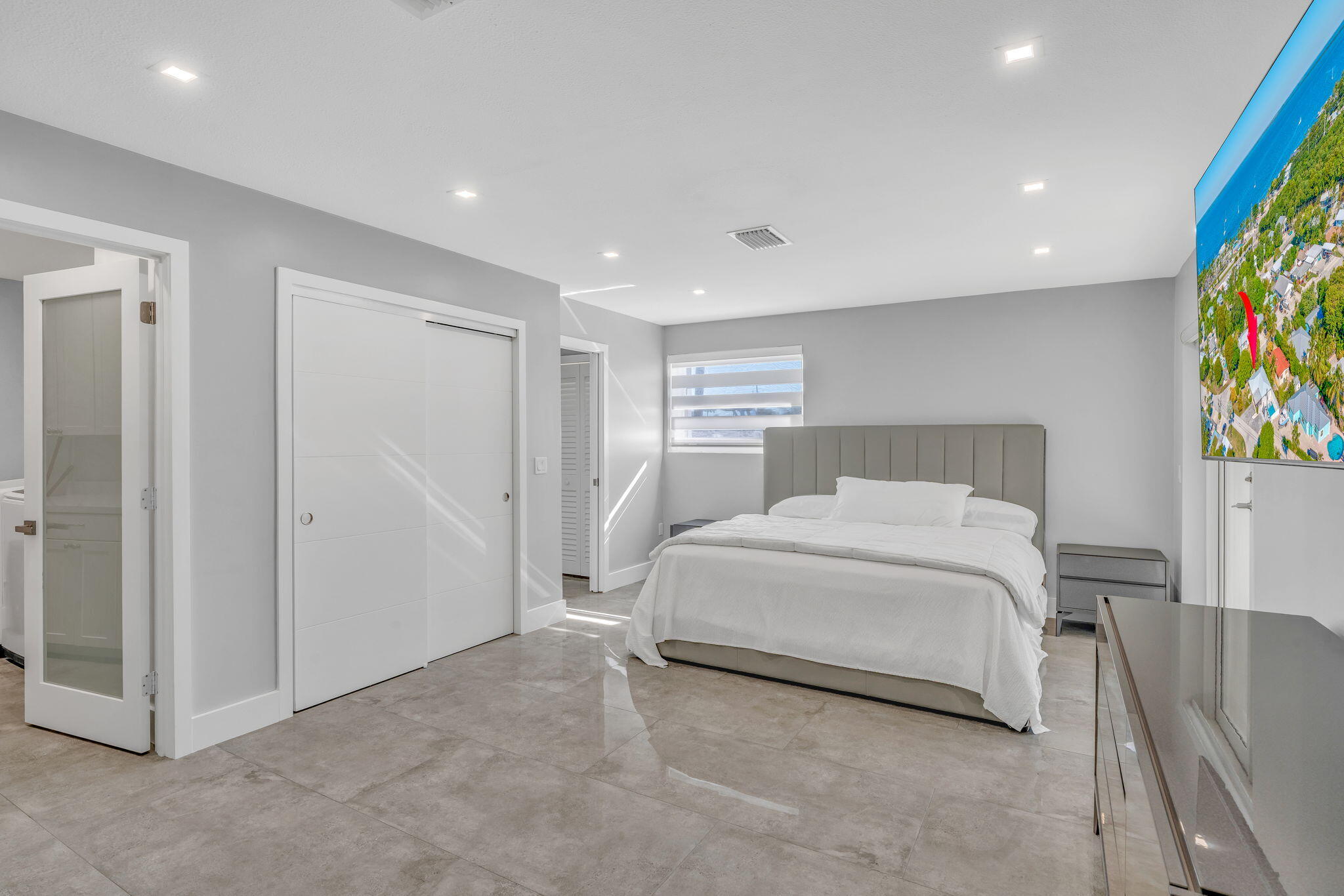 222 2nd Road Key Largo, FL 33037 - Photo 19 of 43 a spacious bedroom with a bed and painting on the wall