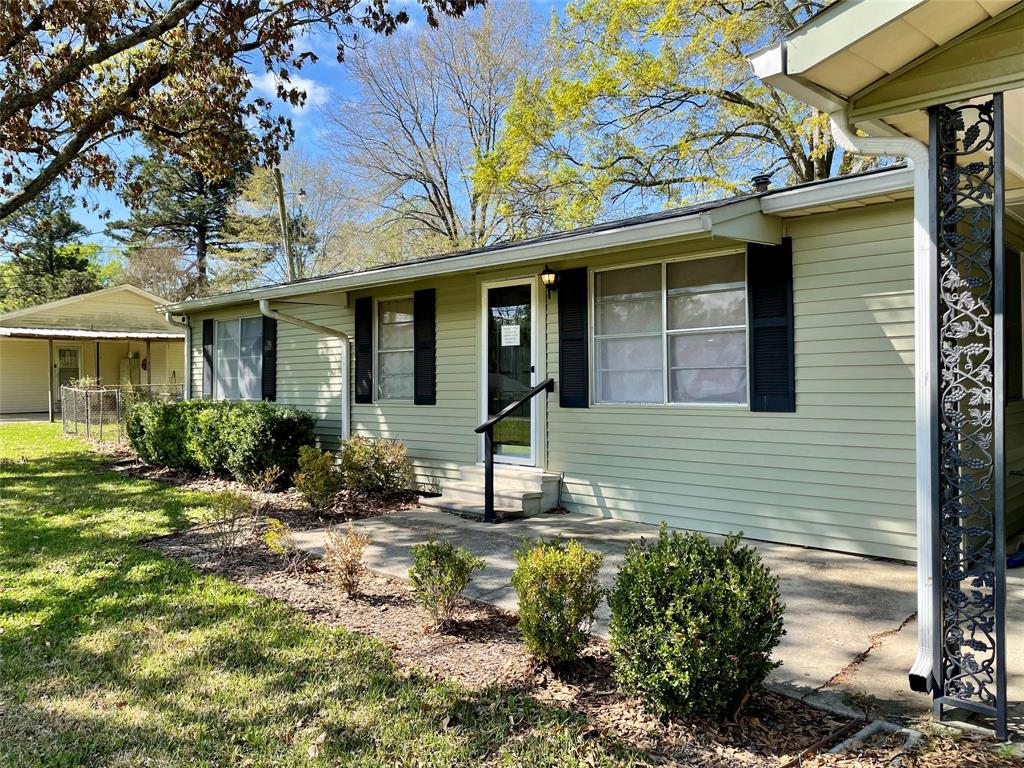 10806 Newson Road Keithville, LA 71047 - Photo 3 of 24 a view of a house with brick walls and a yard with plants
