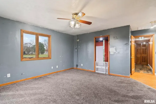 an empty room with fan and windows
