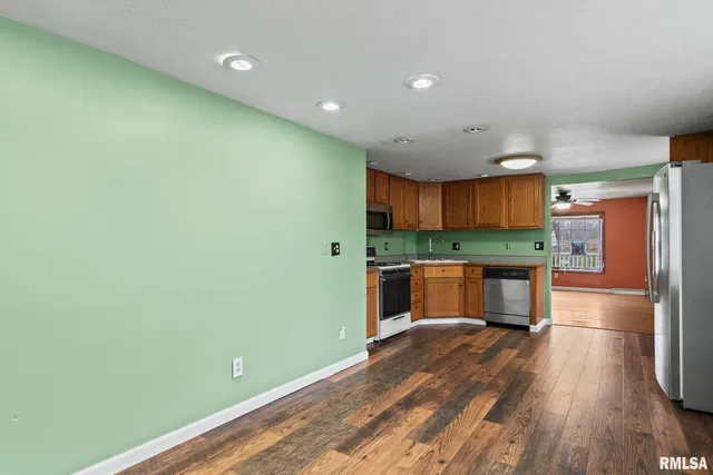 a kitchen with stainless steel appliances a refrigerator and a wooden floors