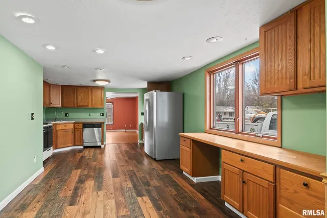 a kitchen with stainless steel appliances wooden floors and wooden cabinets