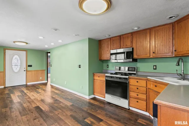 a kitchen with granite countertop stainless steel appliances and wooden cabinets