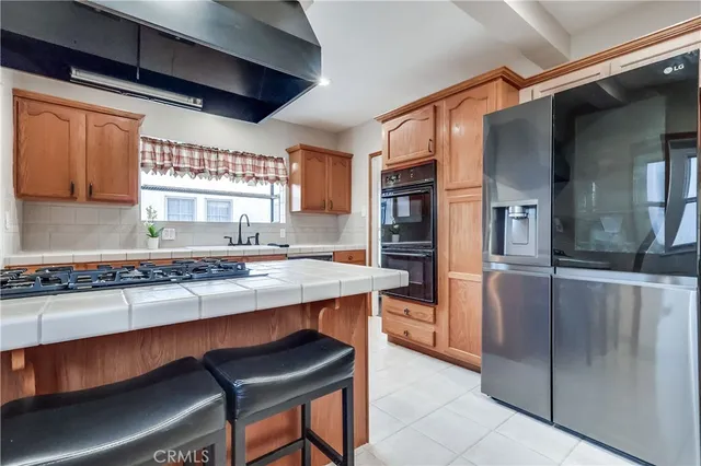 a kitchen with stainless steel appliances granite countertop a sink and a refrigerator
