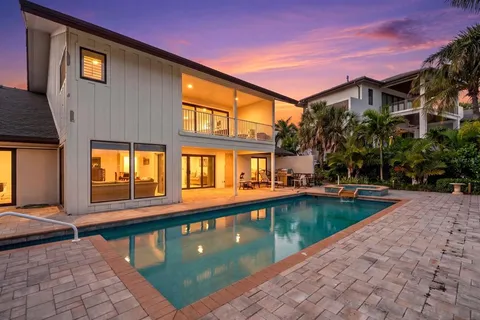 a view of a house with pool and sitting area