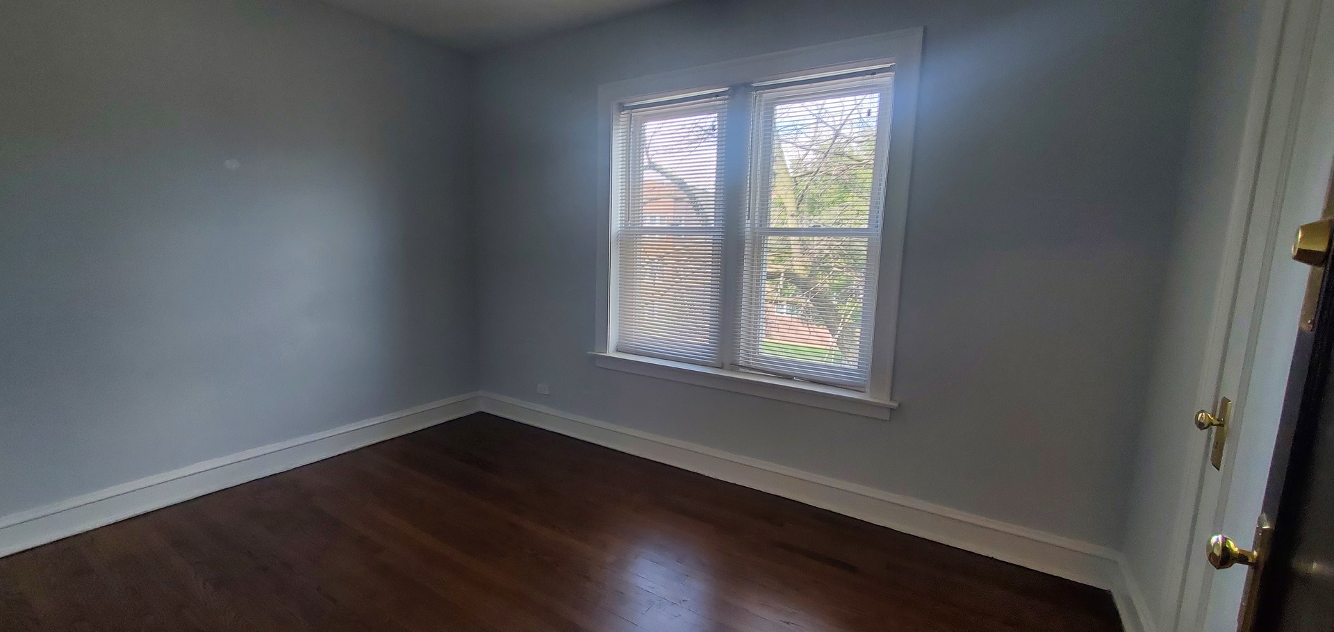 3756 North Kilpatrick Avenue, Unit 2 Chicago, IL 60641 - Photo 5 of 6 an empty room with wooden floor and windows