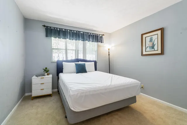 a bed sitting in a bedroom next to a window