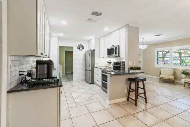 a kitchen with stainless steel appliances kitchen island granite countertop a refrigerator and a stove top oven