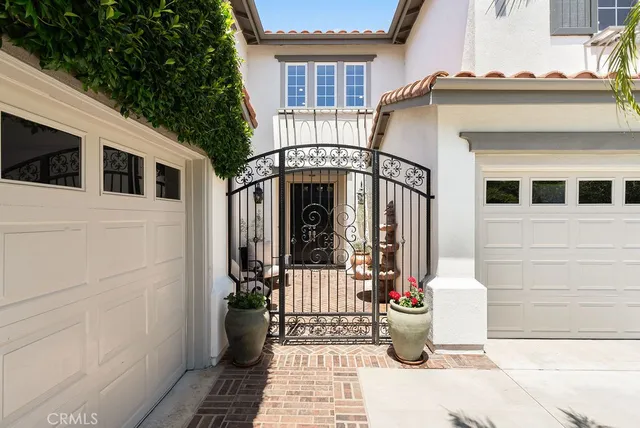 a view of a house with a small yard and potted plants
