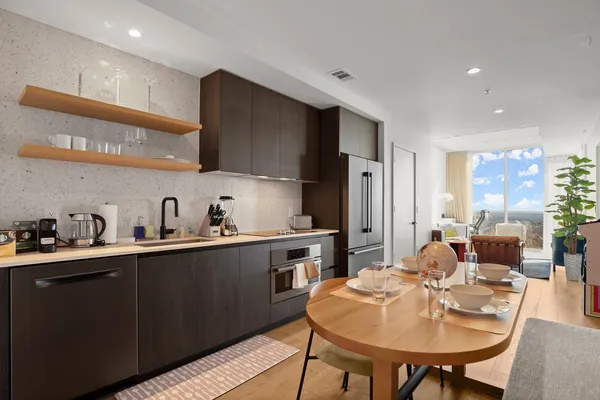 a kitchen with stainless steel appliances stove refrigerator dining table and chairs
