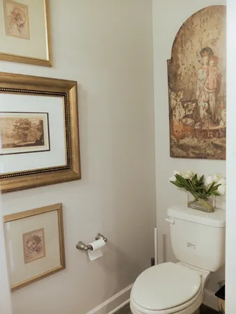 a white toilet sitting next to a bathroom and a shower