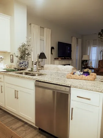 a kitchen with granite countertop white cabinets and white appliances
