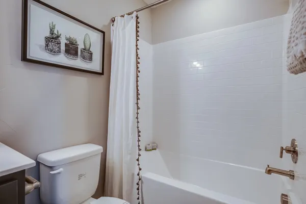 a white toilet sitting next to a bath tub