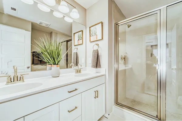 a bathroom with a shower sink and mirror