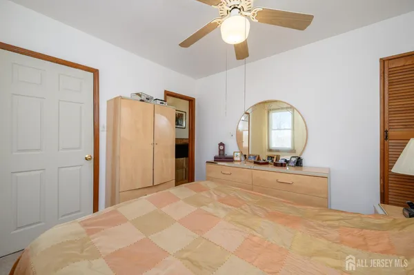 a view of a bedroom with bed and ceiling fan