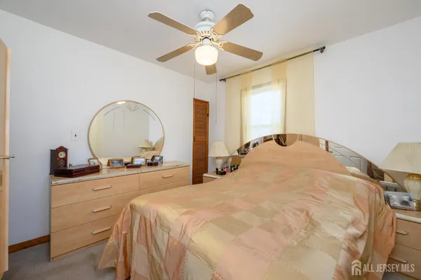 a bedroom with a bed and a dresser with mirror