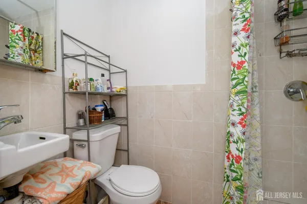 a bathroom with a sink a toilet and shower curtain