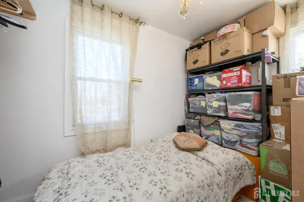 a bedroom with a bed a dresser and next to a window