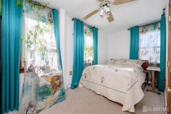 a white bed sitting in a bedroom next to a window