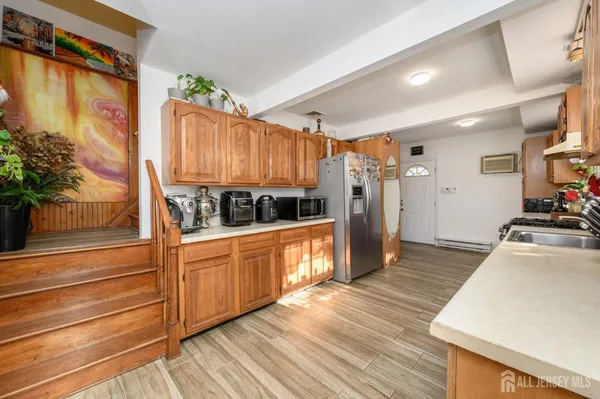 a kitchen with stainless steel appliances granite countertop a refrigerator a stove and a wooden floors