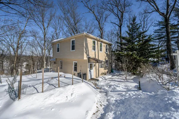 a white house that has a tree in front of it