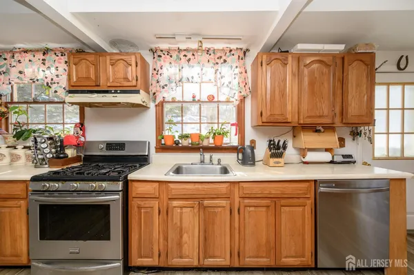 a kitchen with granite countertop a sink stainless steel appliances and cabinets