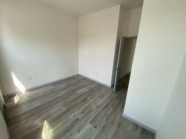 an empty room with wooden floor and closet