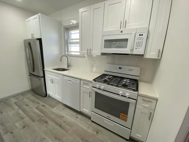 a kitchen with white cabinets and white appliances
