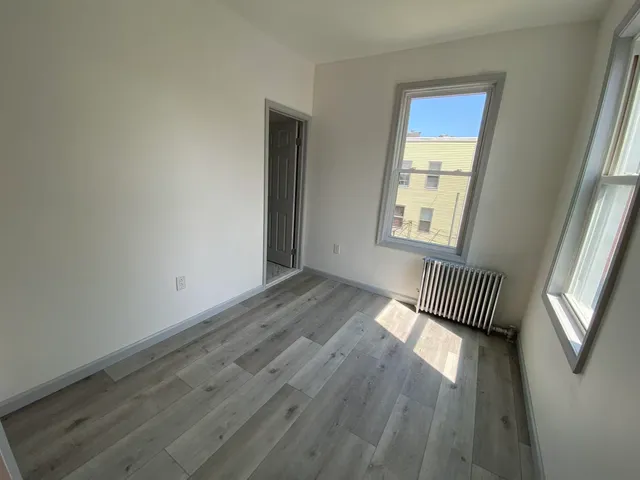 an empty room with wooden floor and a window