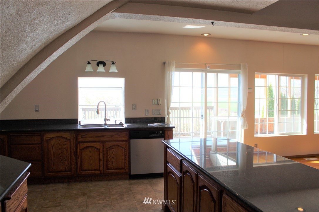 1017 South Sundance Road Othello, WA 99344 - Photo 20 of 34 a kitchen with granite countertop a sink cabinets and window