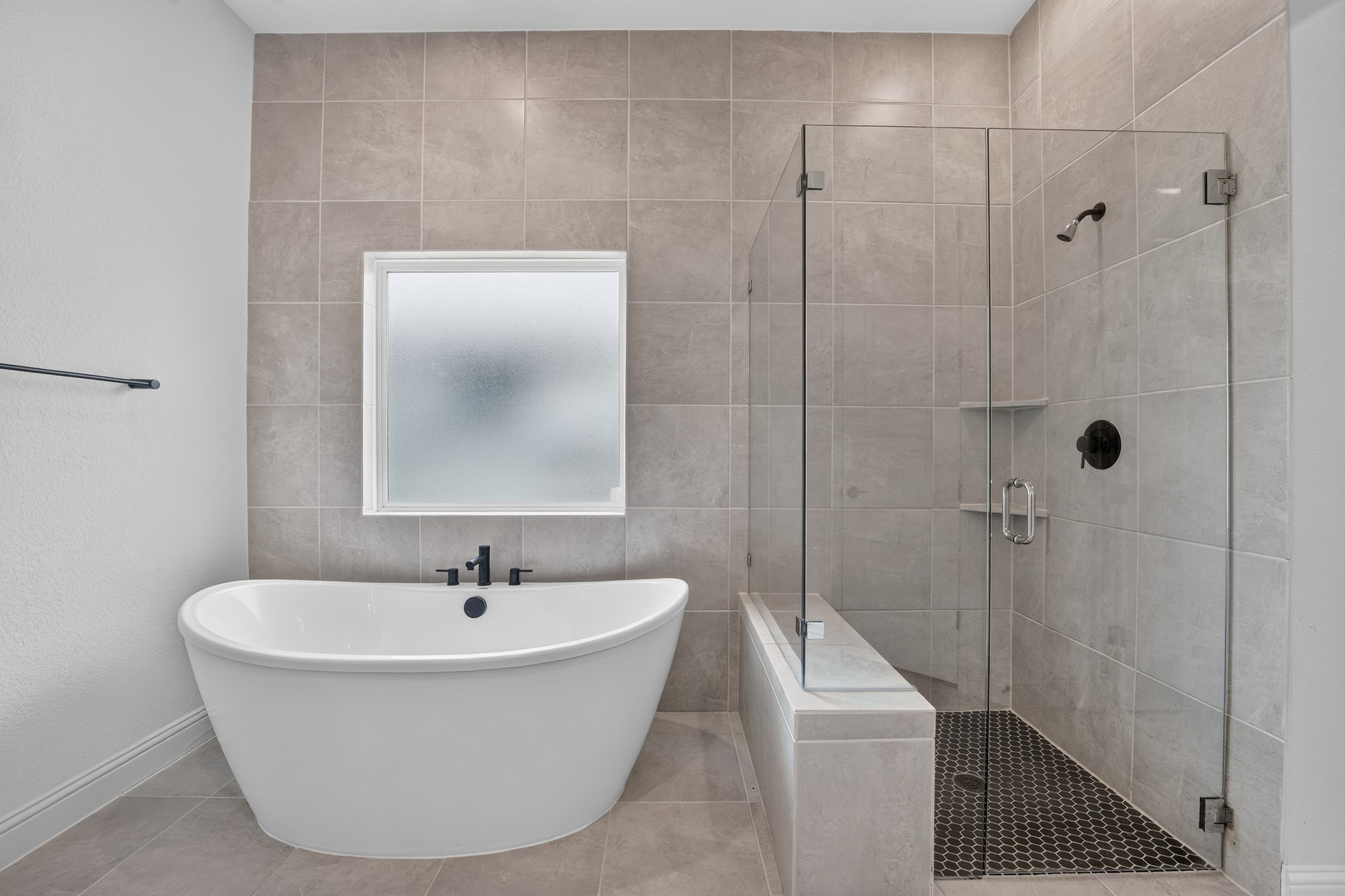 508 Pinnacle View Drive Georgetown, TX 78628 - Photo 16 of 27 A spacious primary bath showcases a modern freestanding soaking tub alongside a walk-in shower with tiled walls.