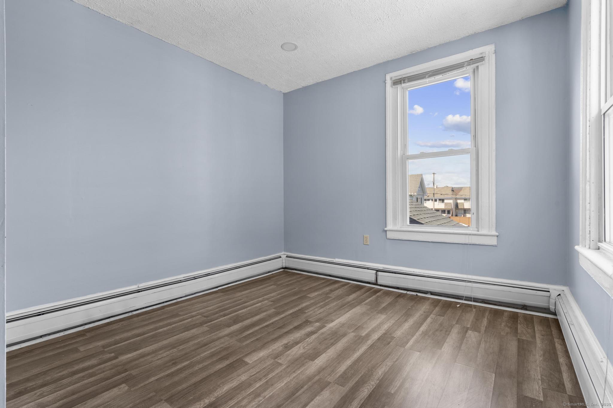 387 Nichols Street, Unit 2 Bridgeport, CT 06608 - Photo 14 of 28 a view of an empty room with wooden floor and a window