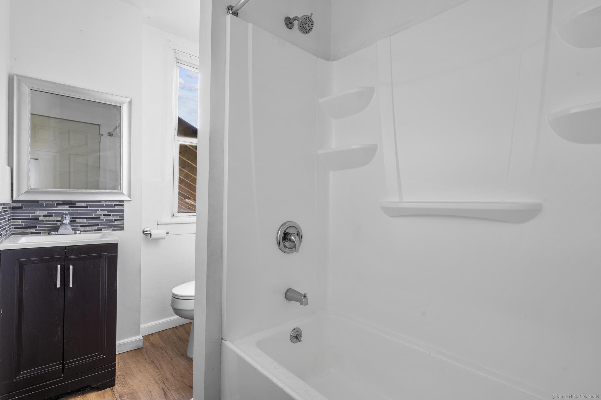 387 Nichols Street, Unit 2 Bridgeport, CT 06608 - Photo 17 of 28 a bathroom with a sink a toilet and shower