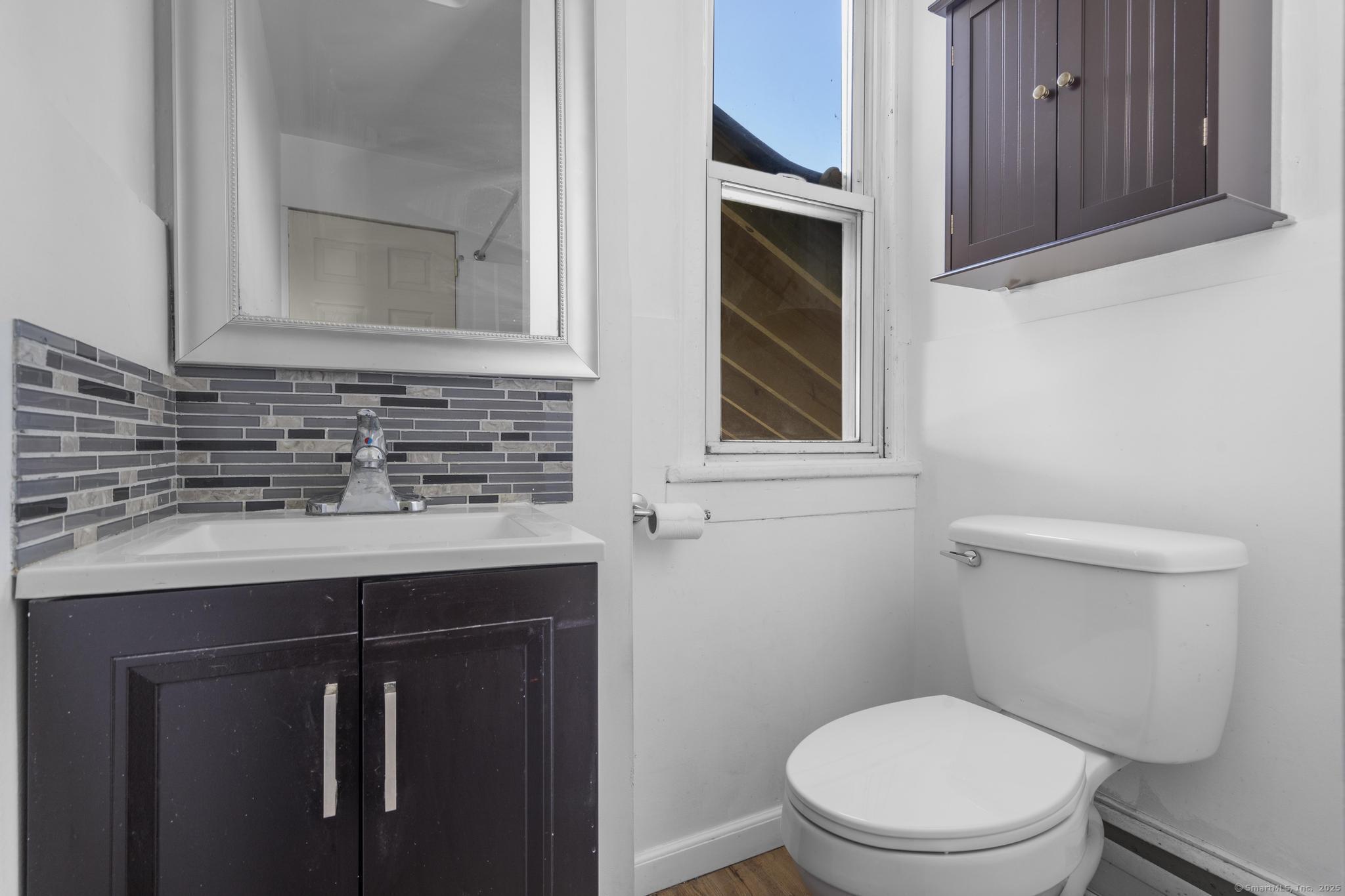 387 Nichols Street, Unit 2 Bridgeport, CT 06608 - Photo 18 of 28 a bathroom with a toilet sink and mirror