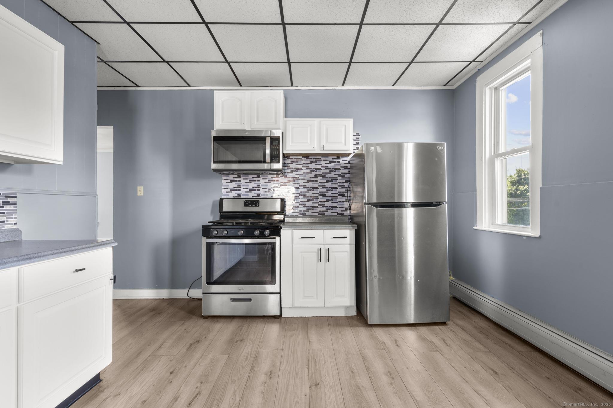 387 Nichols Street, Unit 2 Bridgeport, CT 06608 - Photo 21 of 28 a kitchen with stainless steel appliances a refrigerator sink and microwave