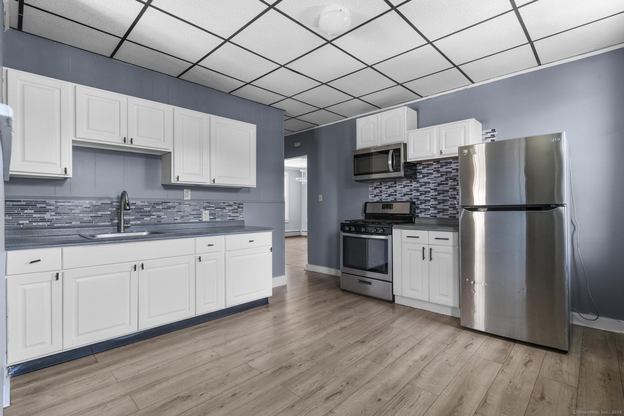 387 Nichols Street, Unit 2 Bridgeport, CT 06608 - Photo 22 of 28 a kitchen with a refrigerator and a stove top oven