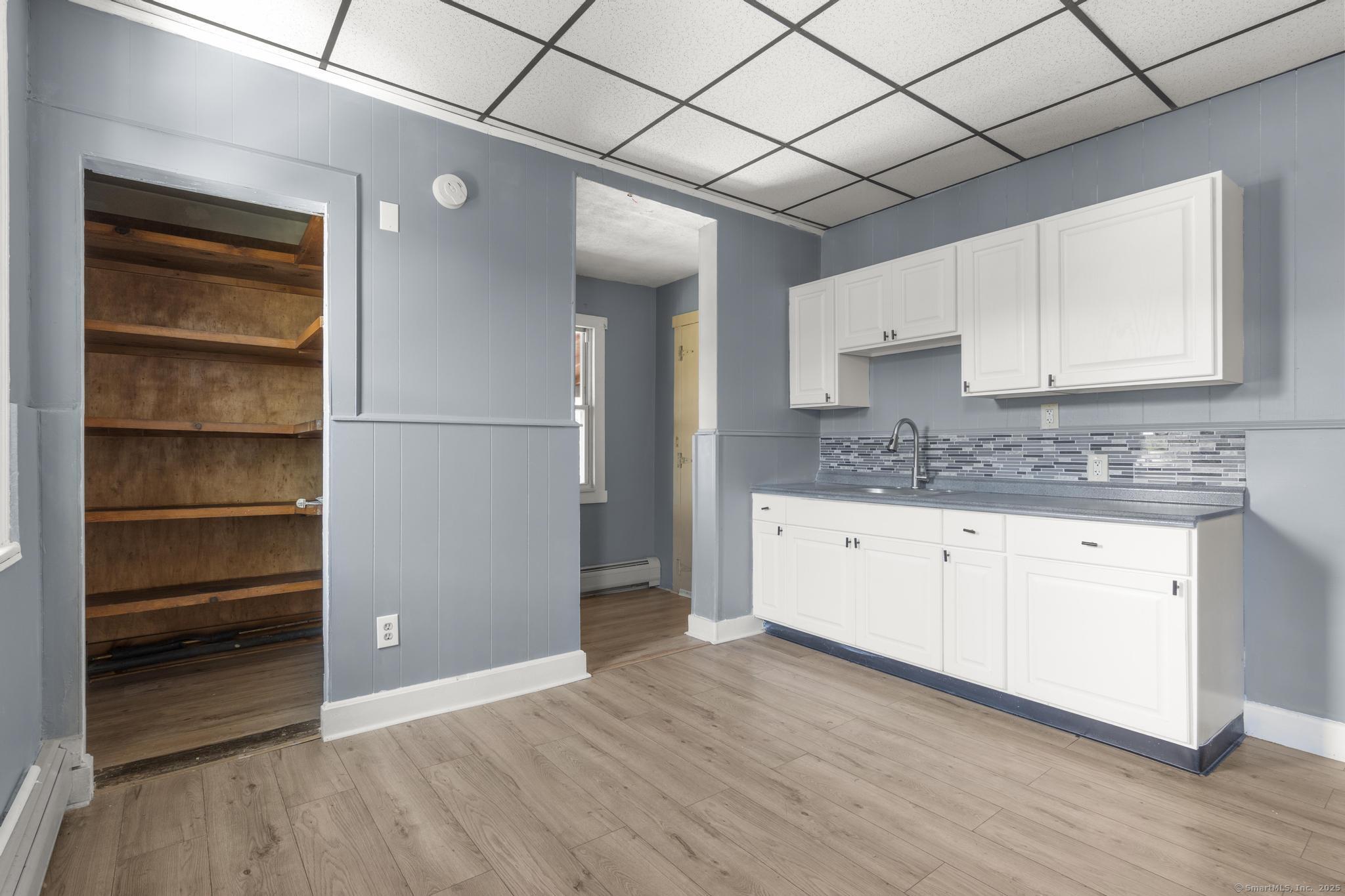 387 Nichols Street, Unit 2 Bridgeport, CT 06608 - Photo 24 of 28 a kitchen with a refrigerator and white cabinets