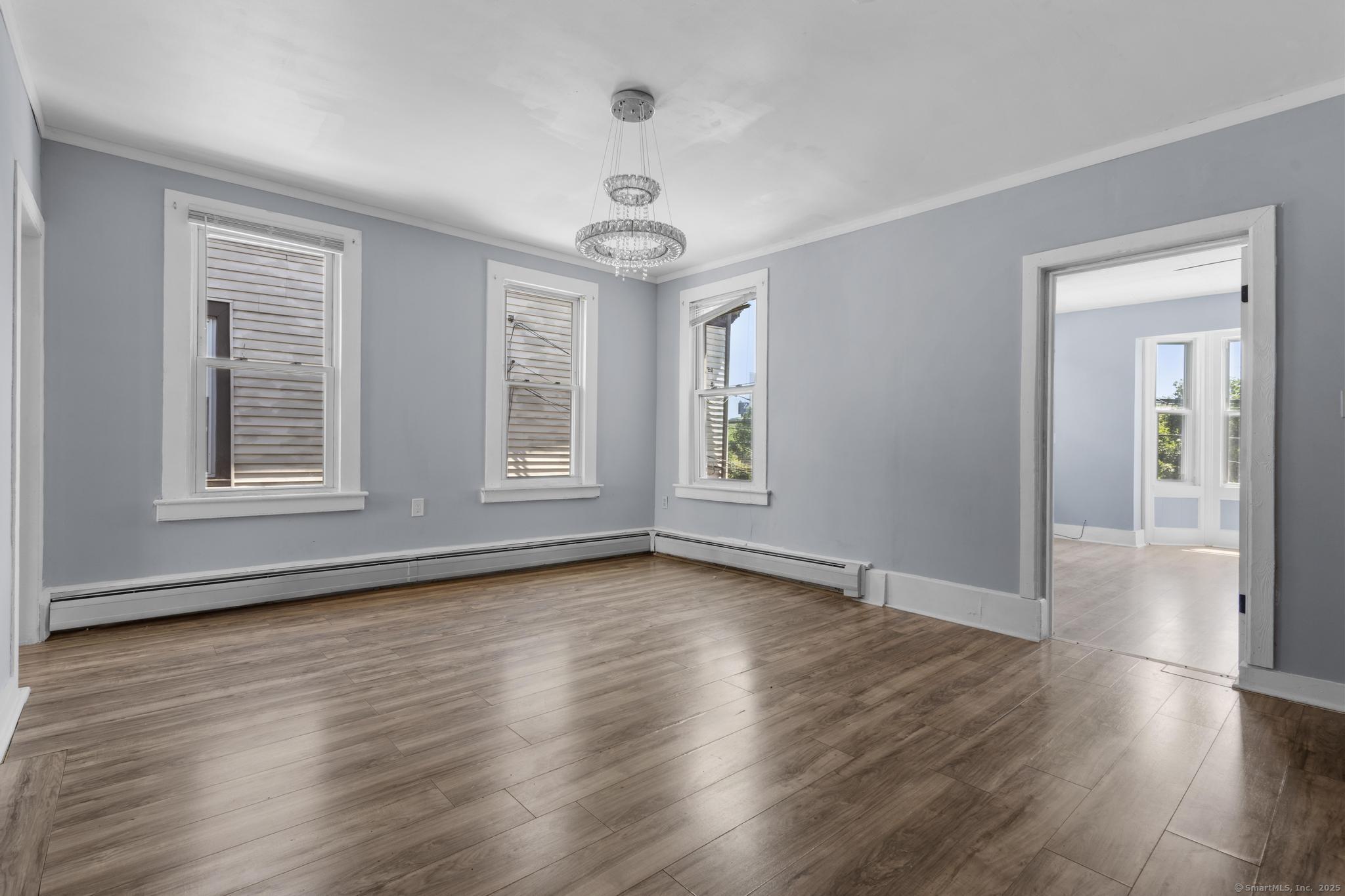 387 Nichols Street, Unit 2 Bridgeport, CT 06608 - Photo 4 of 28 a view of an empty room with wooden floor and a window